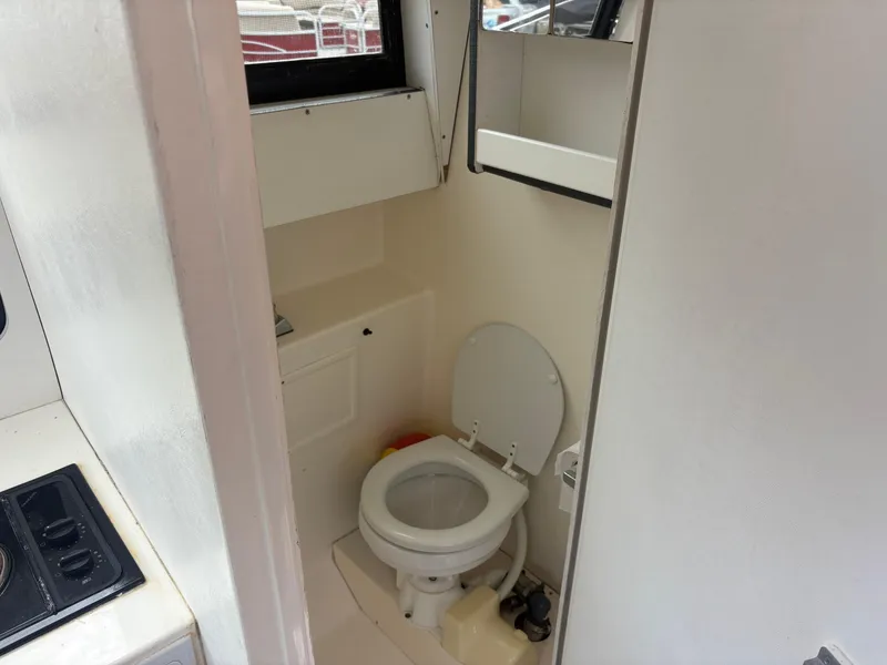 Slide: The Image of 1998 Penn Yan 269 Legend boat bathroom with toilet and compact design. - 16