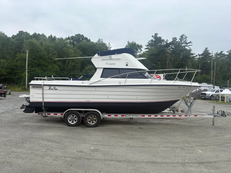Slide: The Image of 1998 Penn Yan 269 Legend boat on trailer, parked outdoors with trees in background. - 2