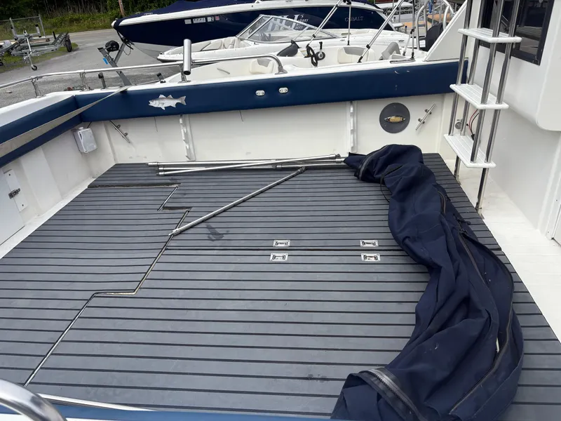 Slide: The Image of 1998 Penn Yan 269 Legend boat deck with blue cover and ladder. - 5