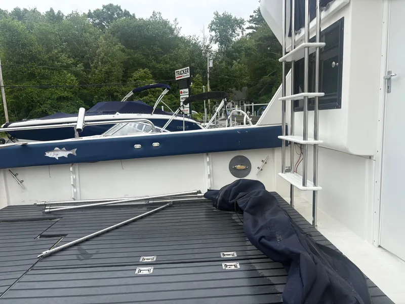 Slide: The Image of 1998 Penn Yan 269 Legend boat deck with railing and ladder, docked near other boats. - 6