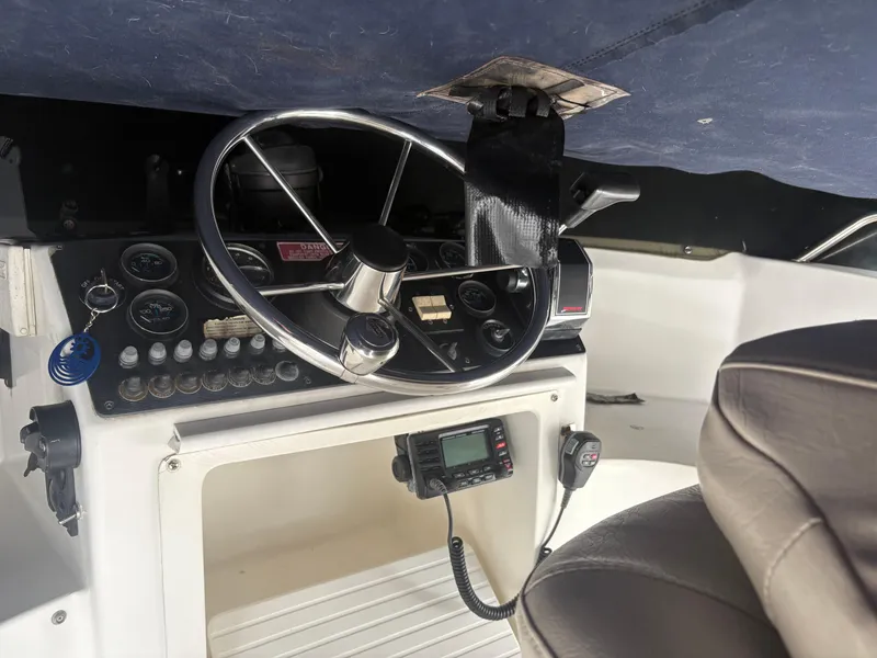 Slide: The Image of 1998 Penn Yan 269 Legend boat dashboard with steering wheel and control panel. - 9