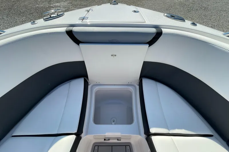Slide: The Image of 2025 Chaparral 270 OSX boat interior with open storage compartment, sleek seating, and modern design. - 17