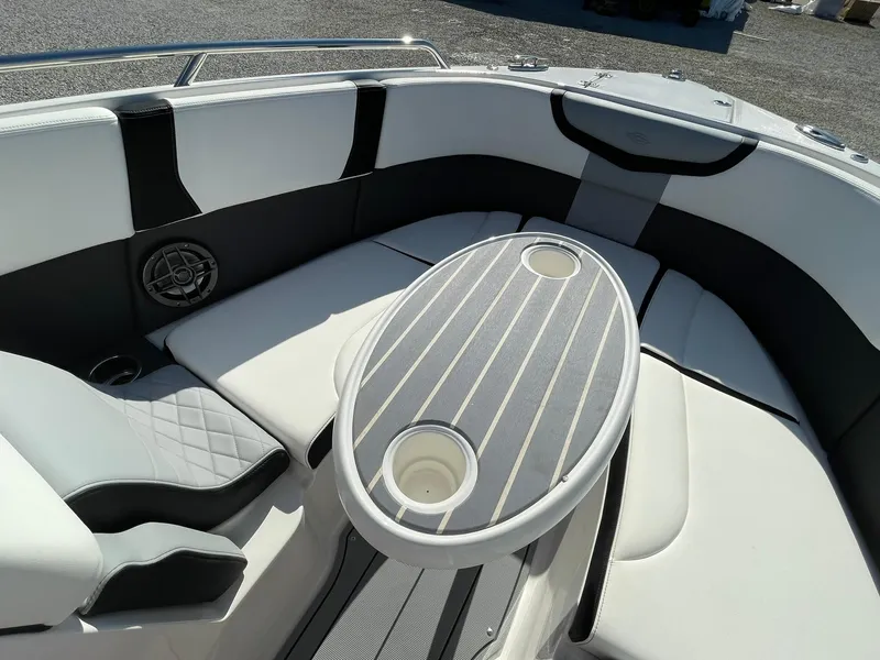Slide: The Image of 2025 Chaparral 270 OSX boat interior with sleek seating and modern table design. - 25