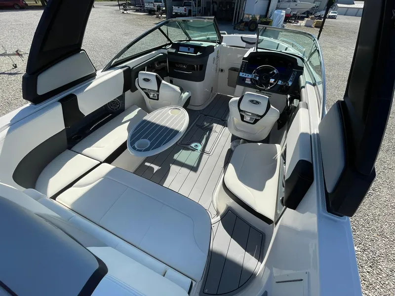 Slide: The Image of 2025 Chaparral 270 OSX boat interior with seating and table, showcasing modern design. - 27