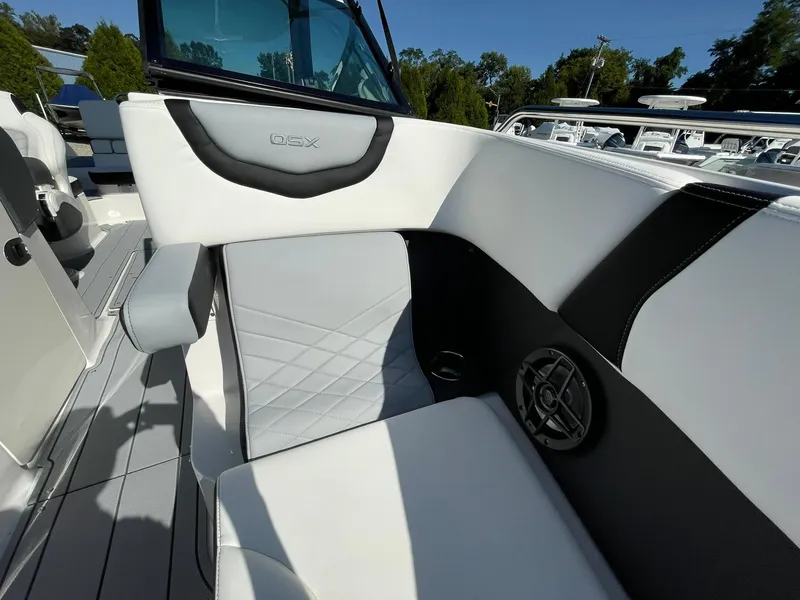 Slide: The Image of 2025 Chaparral 270 OSX boat interior with white and black seating, speaker, and modern design. - 13