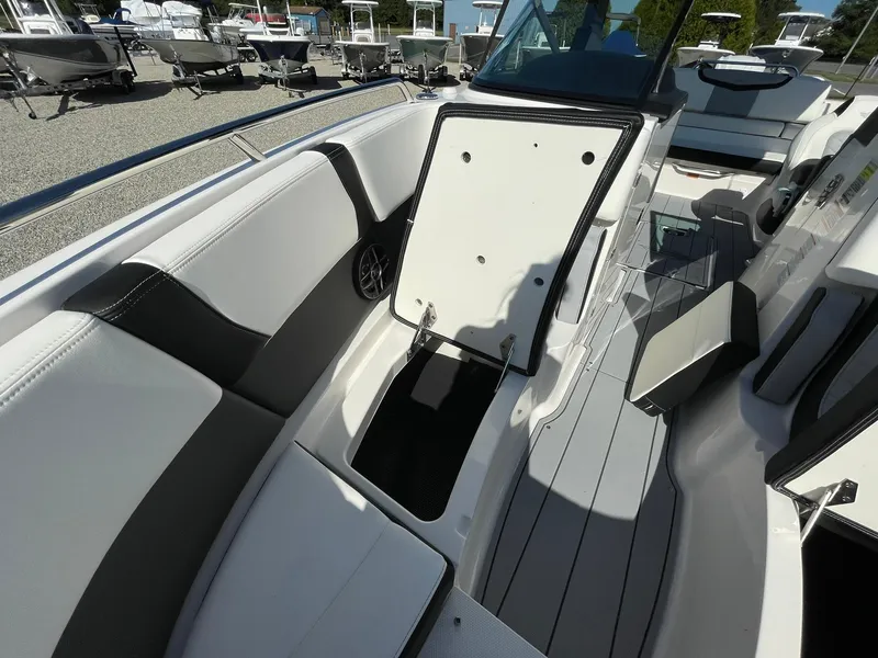 Slide: The Image of 2025 Chaparral 270 OSX boat interior with open storage compartment, sleek seating, and modern design. - 18