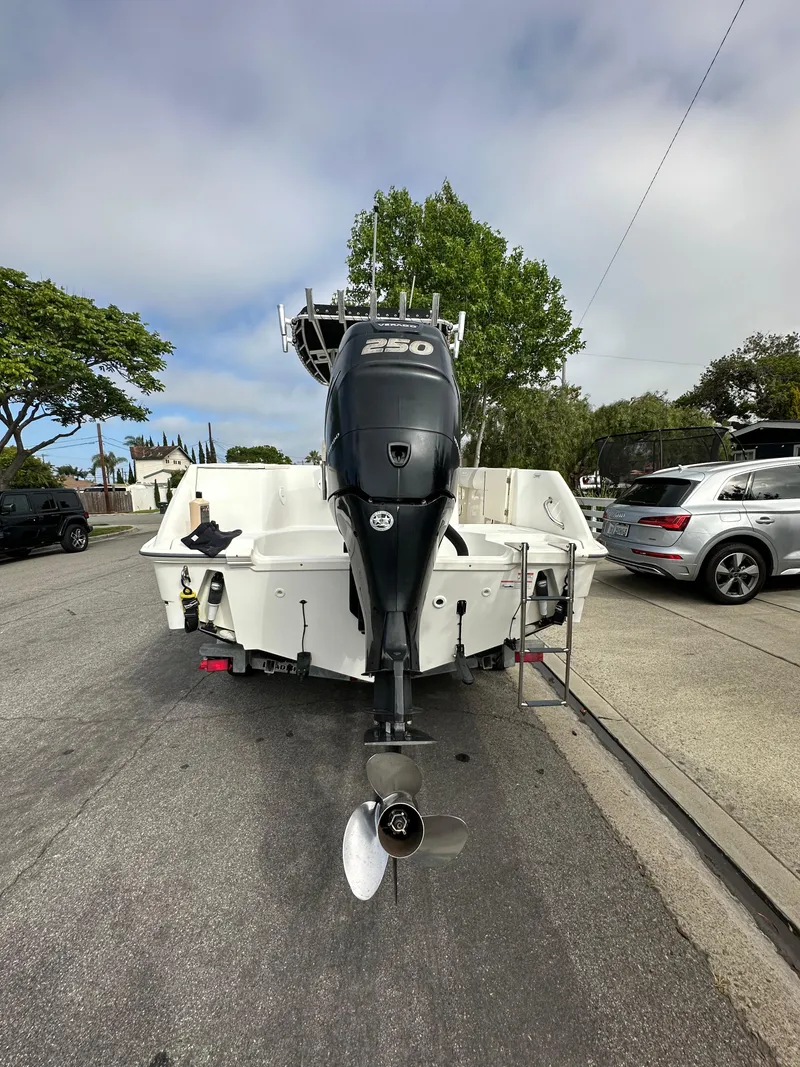 Slide: The Image of 2011 Boston Whaler 220 Outrage boat with powerful outboard motor, parked on street. - 11