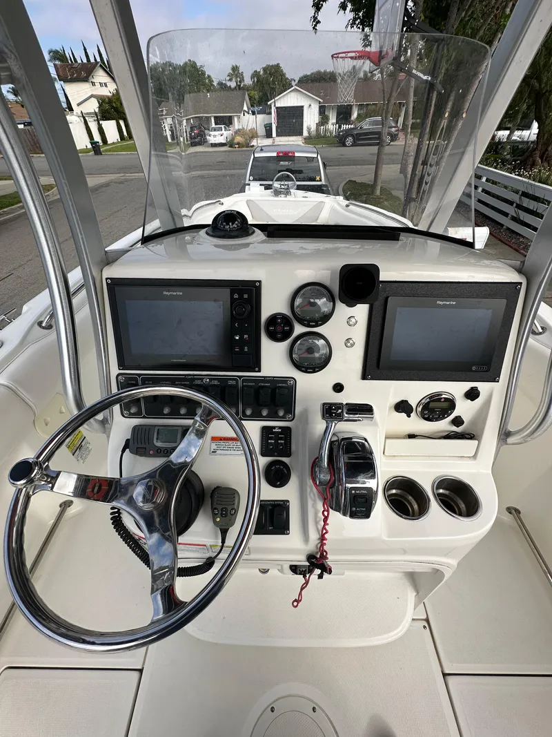 Slide: The Image of 2011 Boston Whaler 220 Outrage boat dashboard with steering wheel and navigation controls. - 15