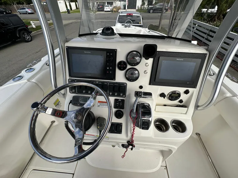 Slide: The Image of 2011 Boston Whaler 220 Outrage boat console with steering wheel and navigation screens. - 16