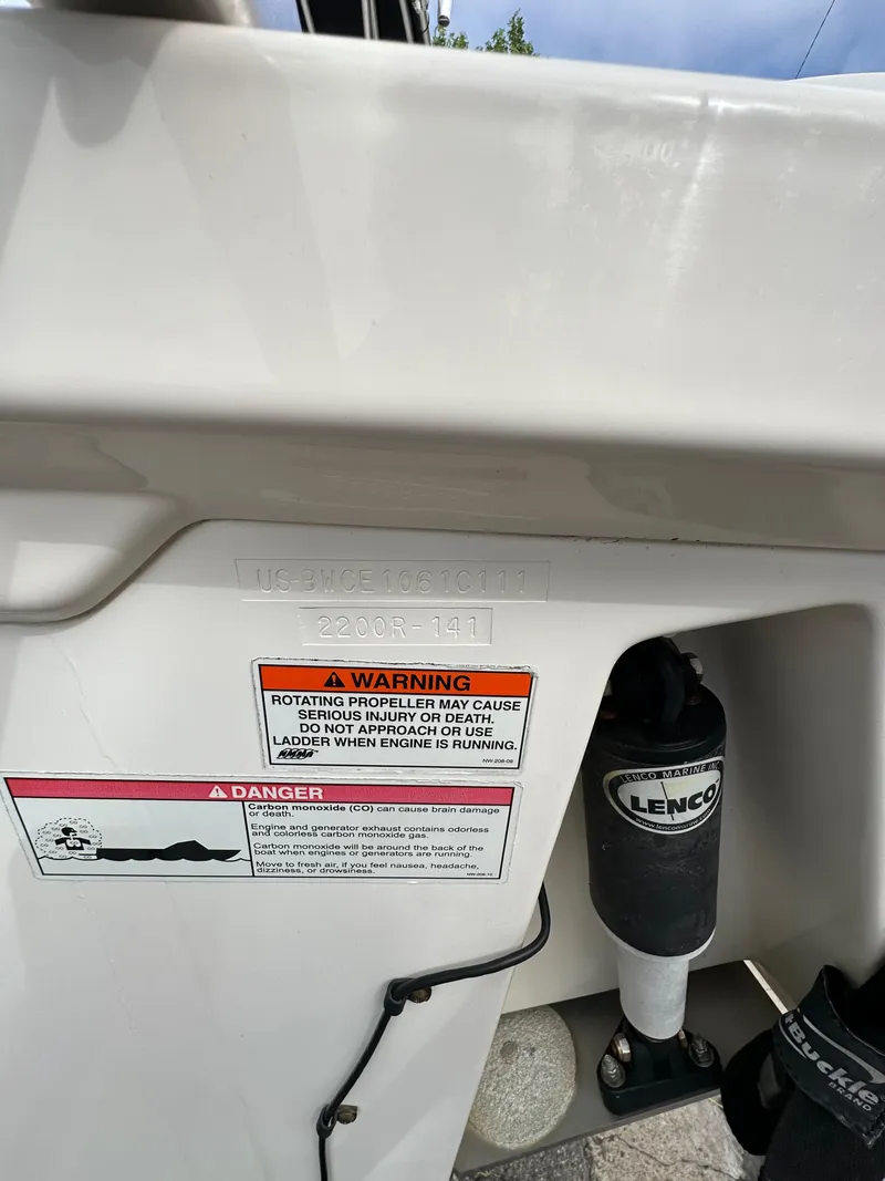 Slide: The Image of 2011 Boston Whaler 220 Outrage boat with warning labels and Lenco trim tab actuator. - 17