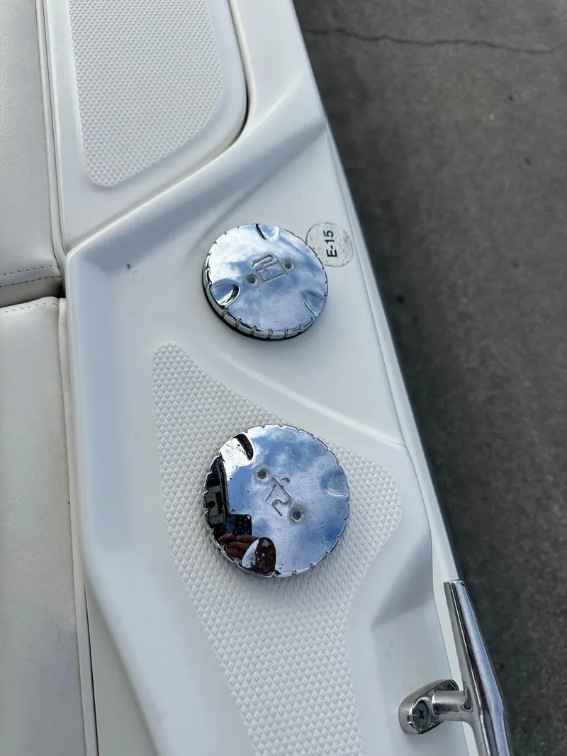 Slide: The Image of 2011 Boston Whaler 220 Outrage fuel caps on white deck. - 23