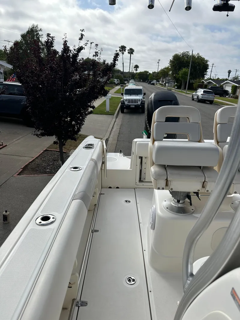 Slide: The Image of 2011 Boston Whaler 220 Outrage boat parked on a residential street. - 24