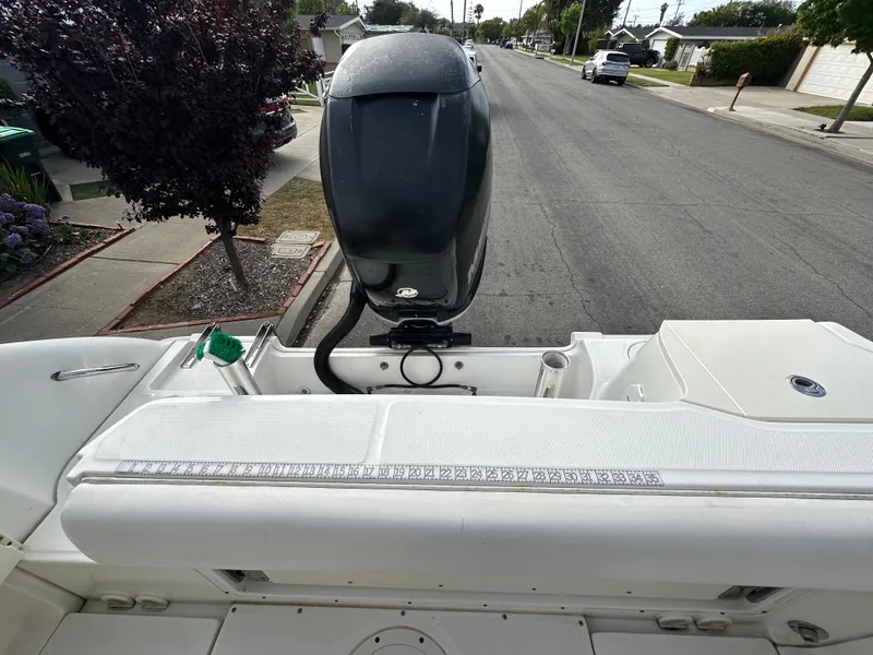 Slide: The Image of 2011 Boston Whaler 220 Outrage boat with outboard motor on a residential street. - 44