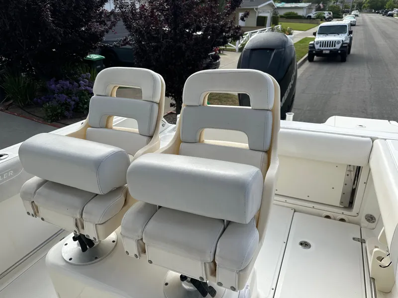 Slide: The Image of Two white cushioned seats on a 2011 Boston Whaler 220 Outrage boat. - 45
