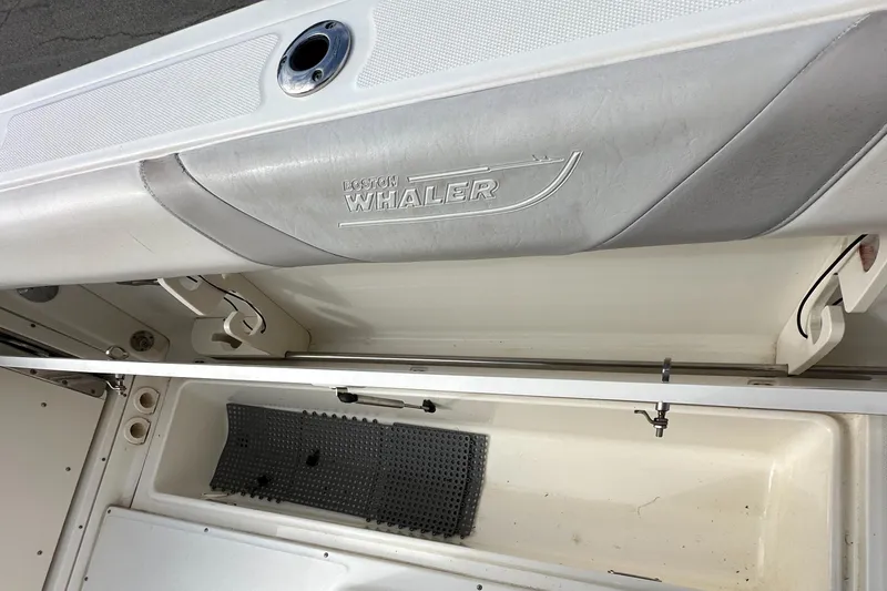 Slide: The Image of 2011 Boston Whaler 220 Outrage boat interior storage compartment with logo detail. - 46