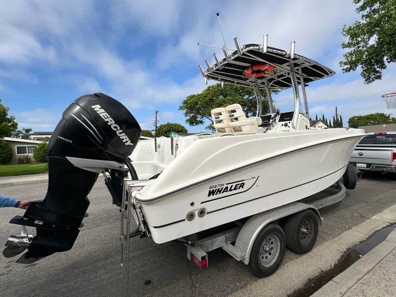Slide: The Image of 2011 Boston Whaler 220 Outrage boat on trailer, featuring Mercury outboard motor. - 8