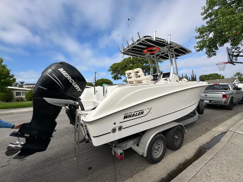 Slide: The Image of 2011 Boston Whaler 220 Outrage boat on trailer with Mercury engine, parked on street. - 9
