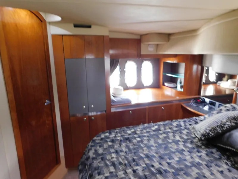 Slide: The Image of Luxurious cabin interior of 2005 Cruisers Yachts 500 Express with wood finishes and cozy bedding. - 31