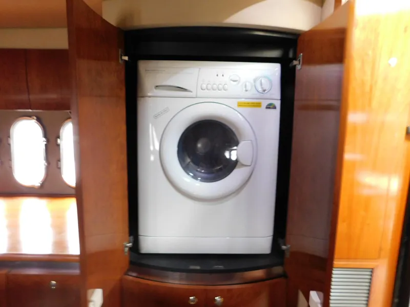 Slide: The Image of Washing machine inside 2005 Cruisers Yachts 500 Express, wooden cabinet, porthole windows. - 33