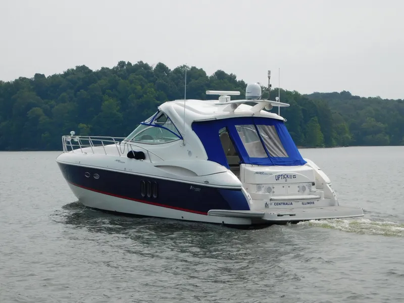 Slide: The Image of 2005 Cruisers Yachts 500 Express on a serene lake with lush green background. - 48