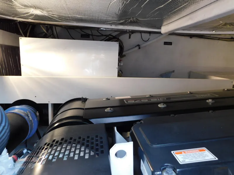 Slide: The Image of Engine room of 2005 Cruisers Yachts 500 Express, showcasing mechanical components and wiring. - 49