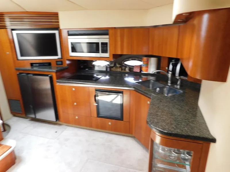 Slide: The Image of Luxurious 2005 Cruisers Yachts 500 Express kitchen with modern appliances and sleek wood cabinetry. - 11