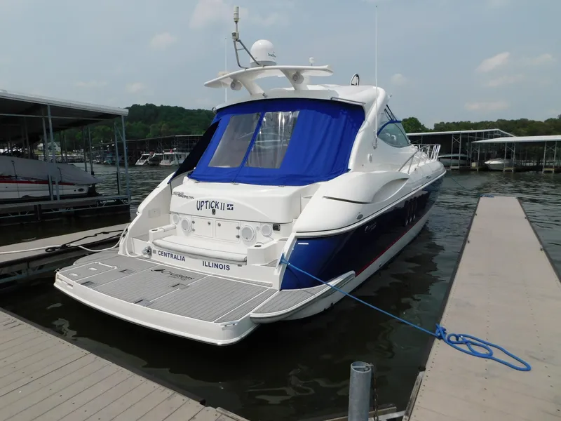 Slide: The Image of 2005 Cruisers Yachts 500 Express docked, featuring sleek design and blue canopy. - 13