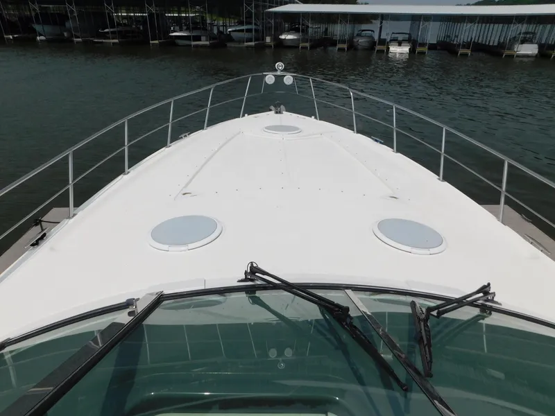 Slide: The Image of 2005 Cruisers Yachts 500 Express boat deck view with railing, docked at marina. - 22