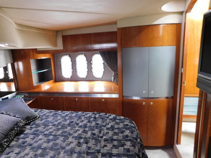 Slide: The Image of Luxurious 2005 Cruisers Yachts 500 Express bedroom with wood cabinetry and elegant bedding. - 32