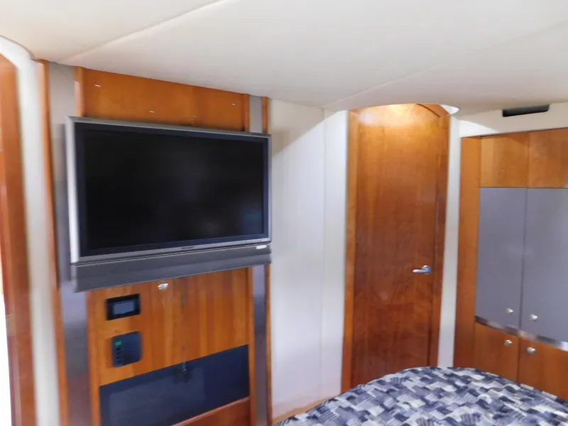 Slide: The Image of Interior of 2005 Cruisers Yachts 500 Express with TV and wooden cabinetry. - 34