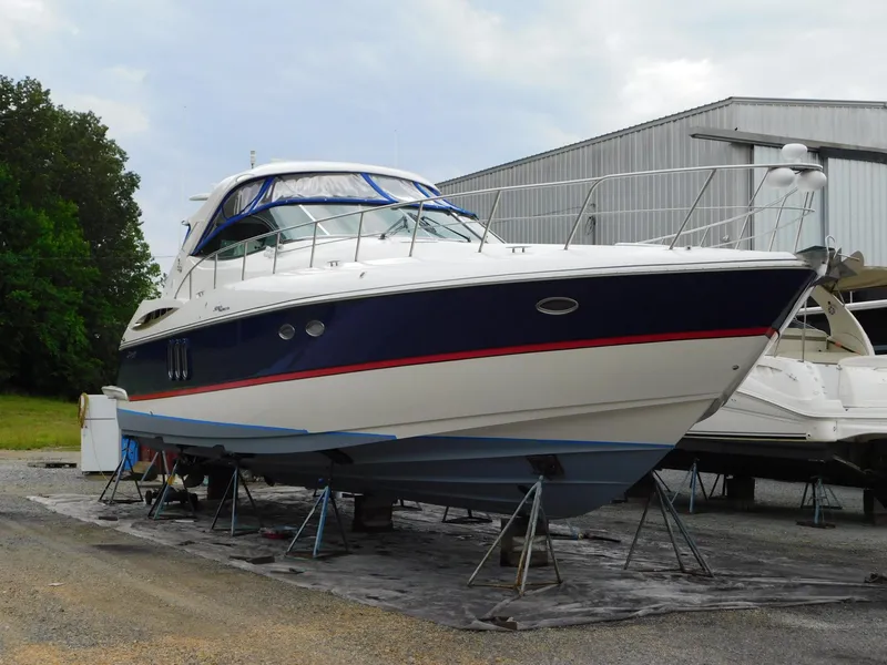 Slide: The Image of 2005 Cruisers Yachts 500 Express on stands, blue and white hull, outdoor storage. - 4