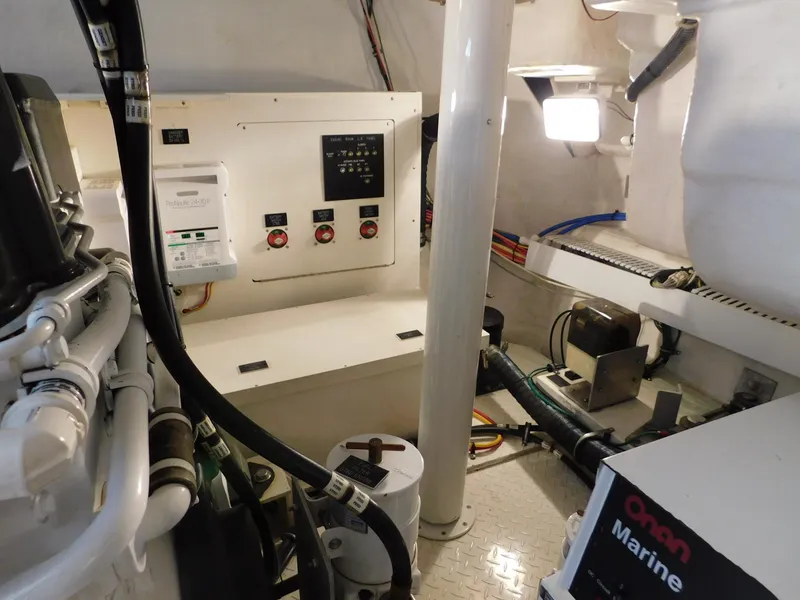 Slide: The Image of Engine room of 2005 Cruisers Yachts 500 Express, featuring control panels and marine equipment. - 44