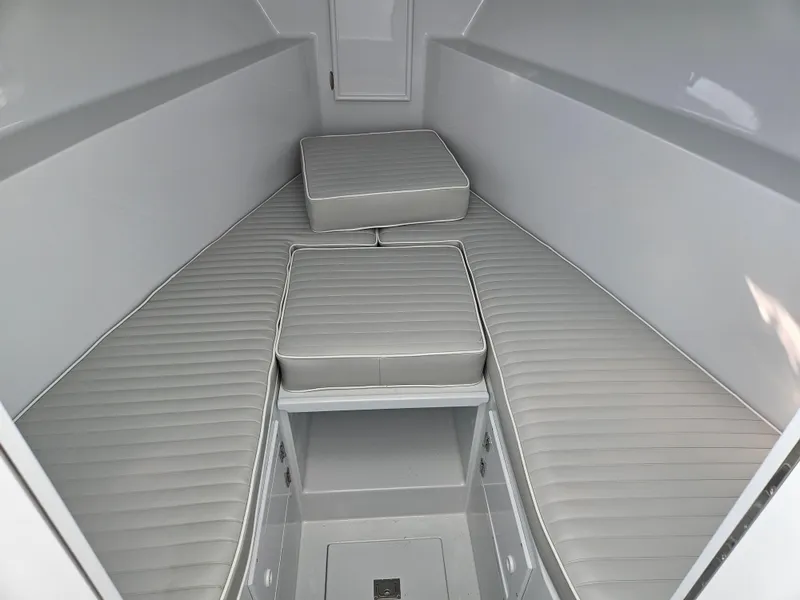 Slide: The Image of Interior of a 1994 Tides 27 Sportfish boat, featuring cushioned seating and storage compartments. - 6