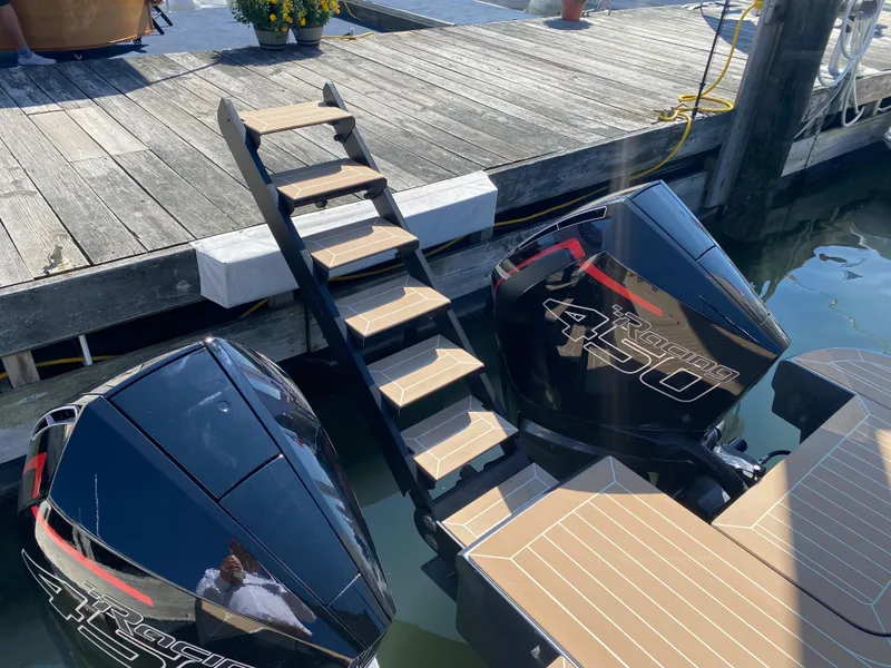 Slide: The Image of Staircase leading to dock over Solaris Power 40F open 2024 boat engines. - 14