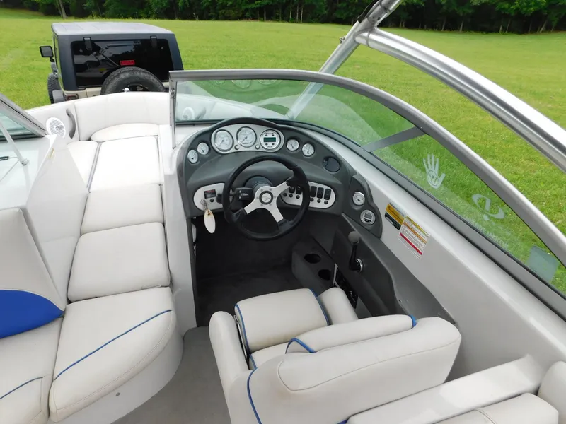 Slide: The Image of 2004 Moomba 23XLV boat interior with steering wheel and dashboard, featuring white seating. - 14