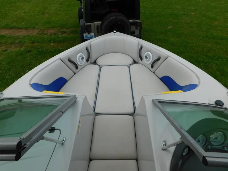 Slide: The Image of 2004 Moomba 23XLV boat interior with gray and blue seating, parked on grass. - 16