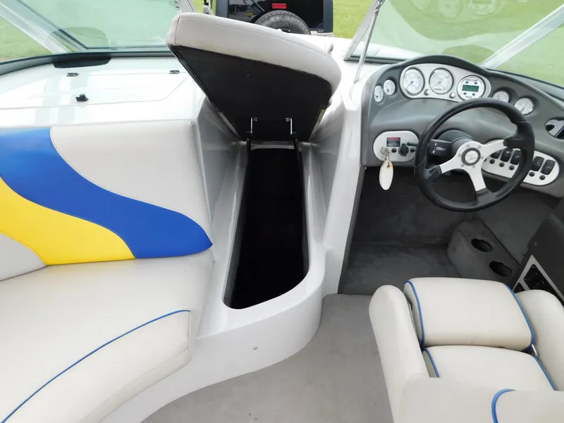 Slide: The Image of 2004 Moomba 23XLV boat interior with open storage, steering wheel, and colorful seating. - 18