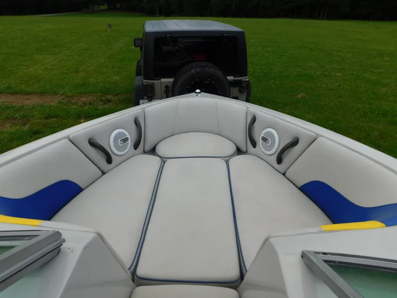 Slide: The Image of 2004 Moomba 23XLV boat interior with speakers, parked on grass, Jeep in background. - 24