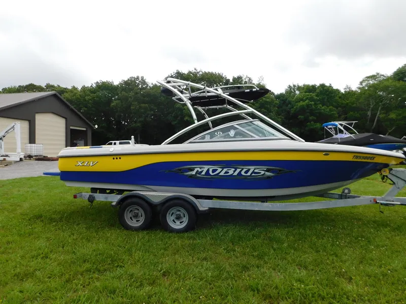 Slide: The Image of 2004 Moomba 23XLV boat on trailer, parked on grass near a building. - 8