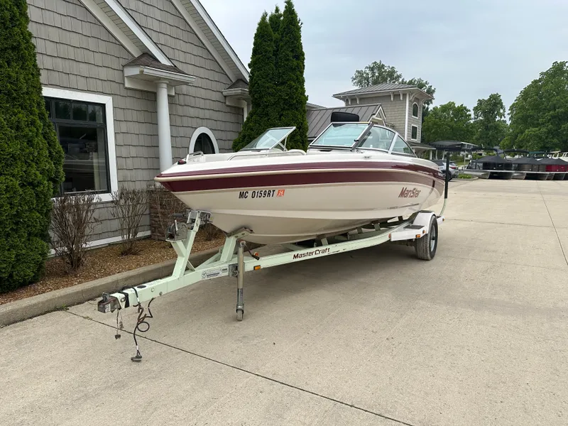 Slide: The Image of 1999 MasterCraft MariStar 210 VRS boat on trailer, parked in driveway. - 2
