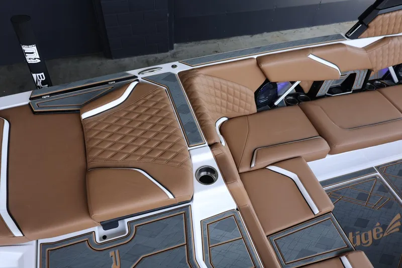 Slide: The Image of 2025 Tigé 24RZX boat interior with brown quilted seats and modern design. - 12