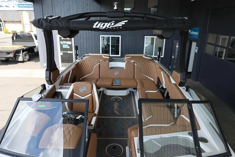 Slide: The Image of 2025 Tigé 24RZX boat interior with brown leather seating and modern design. - 24