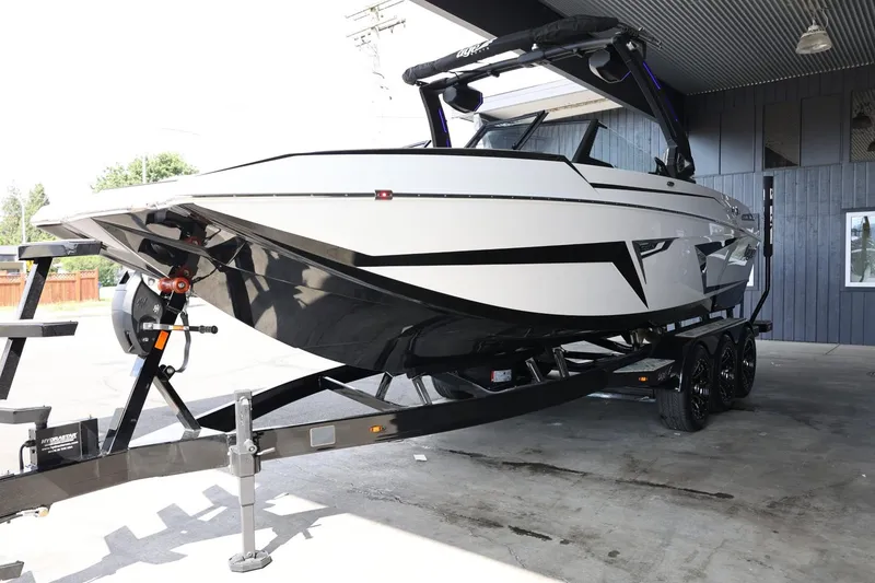 Slide: The Image of 2025 Tigé 24RZX boat on trailer, sleek design, parked under a shelter. - 4