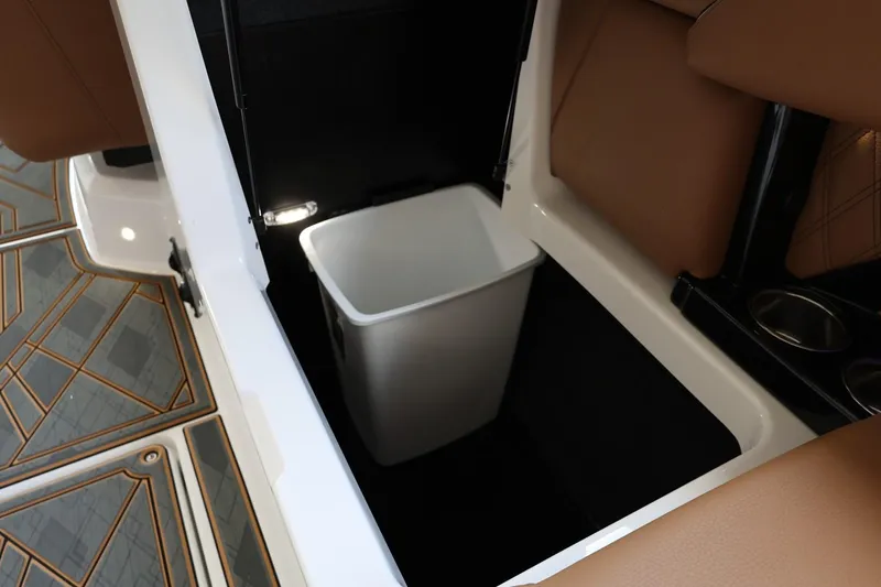 Slide: The Image of 2025 Tigé 24RZX boat interior with built-in storage compartment and trash bin. - 46