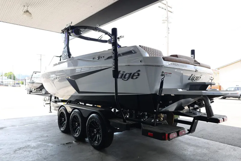 Slide: The Image of 2025 Tigé 24RZX boat on trailer, parked under a canopy, showcasing sleek design. - 6