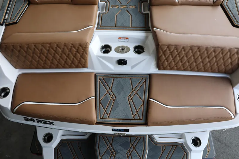 Slide: The Image of 2025 Tigé 24RZX boat interior with tan diamond-stitched seats and sleek design. - 9