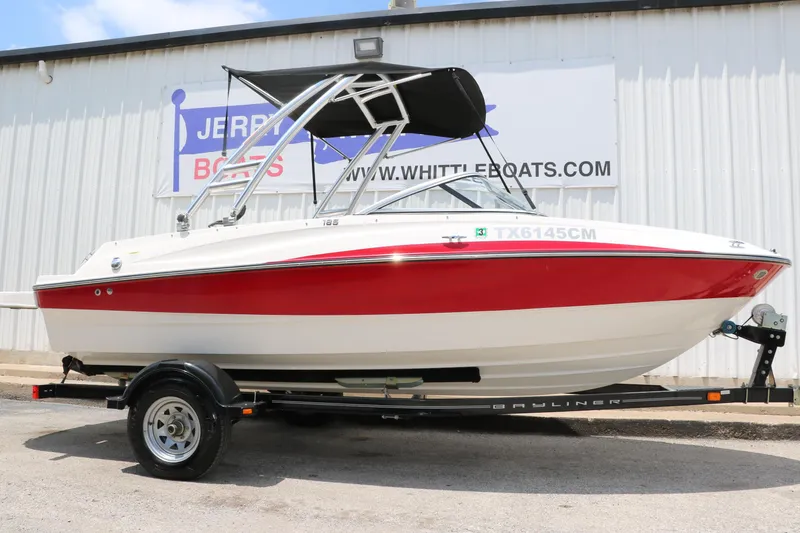 The Image of 2014 Bayliner 185 BR boat with red and white design on a trailer. - 1