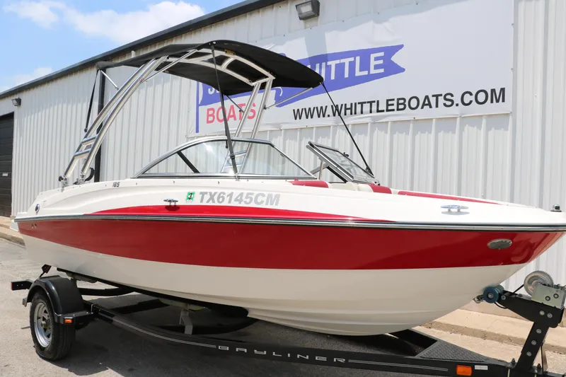 Slide: The Image of 2014 Bayliner 185 BR boat with red and white design on a trailer. - 12