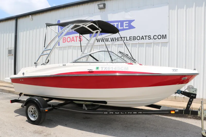 Slide: The Image of 2014 Bayliner 185 BR boat with red and white design on a trailer. - 13