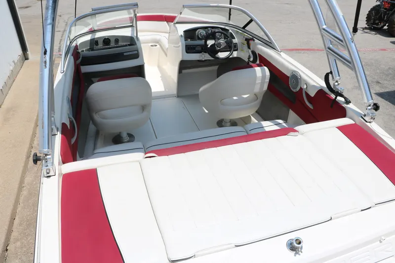Slide: The Image of 2014 Bayliner 185 BR boat interior with red and white seating and steering console. - 14